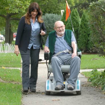 Caregiver providing mobility assistance to elderly client