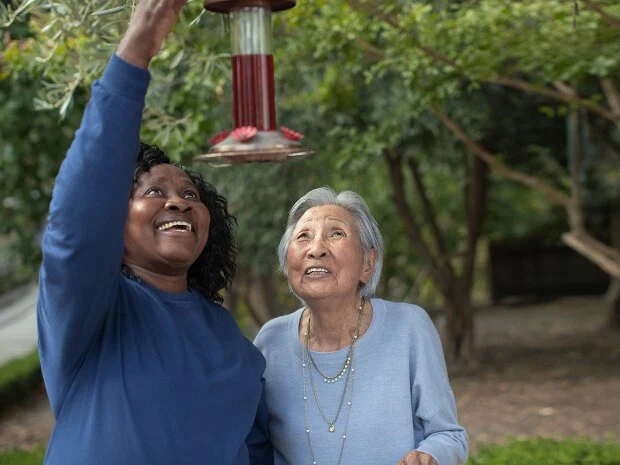 Caring companion helping elderly woman with outdoor activities